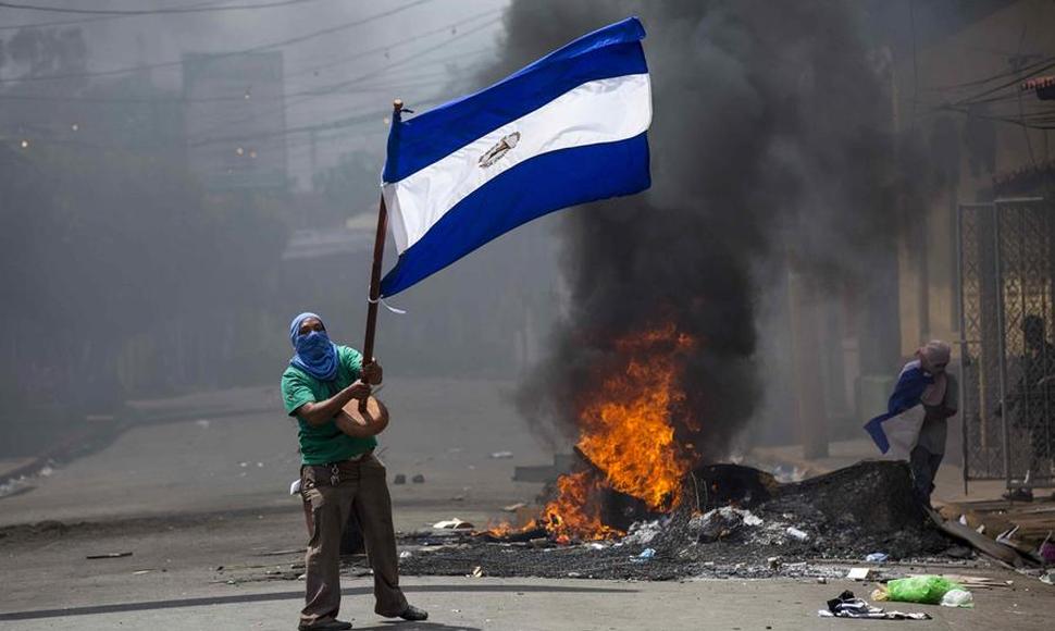Protestantes ondean la bandera nacional, símbolo de la resistencia cívica.